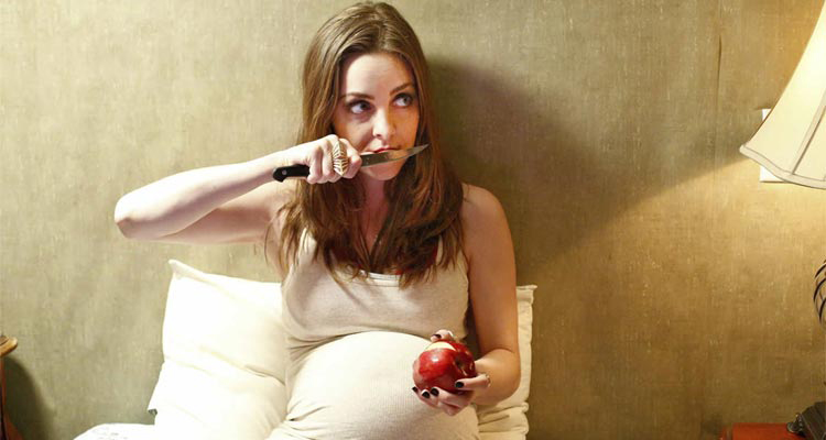 Une femme enceinte mangeant une pomme