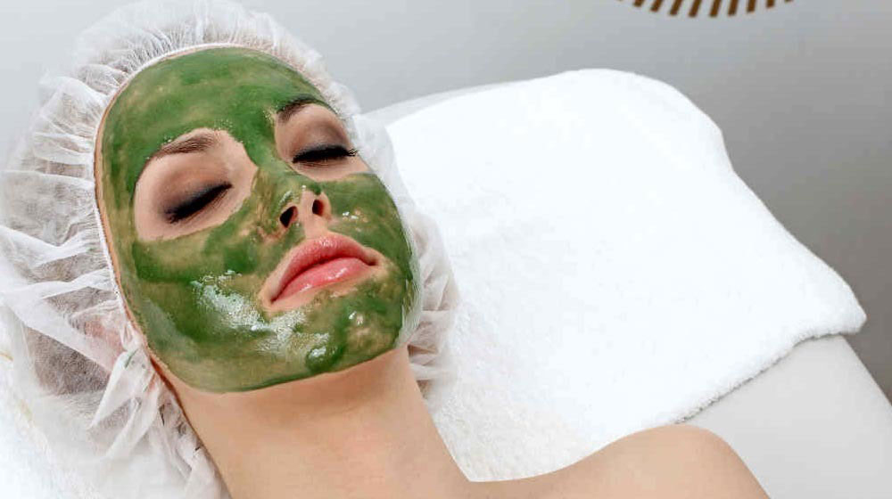 Une femme avec un masque à la spiruline sur le visage