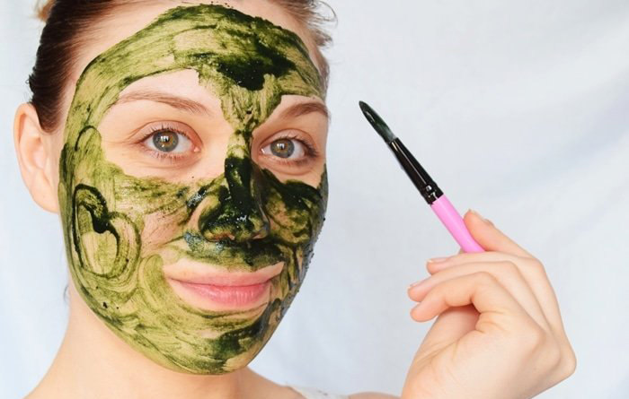 Une femme avec un masque à la spiruline sur le visage